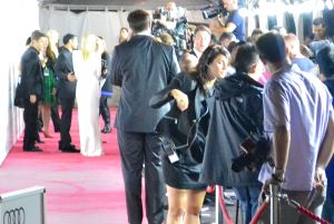 In the far left: Kate in a white dress about to make her way inside